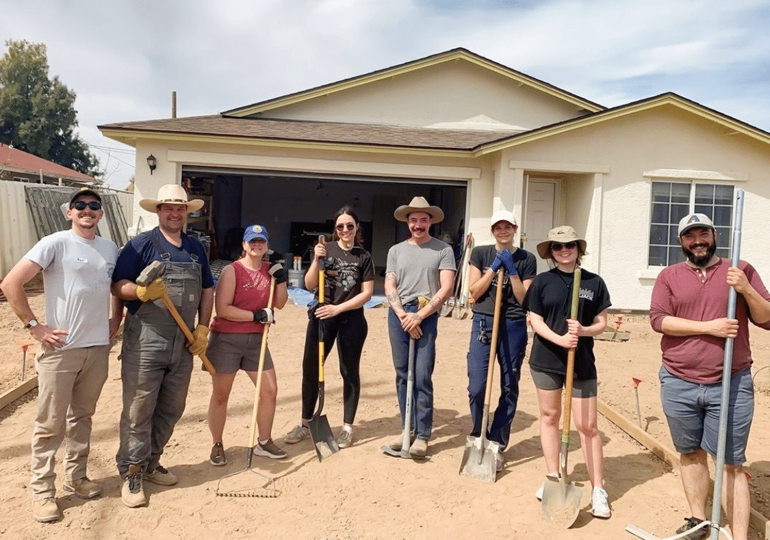 Cartel Team holding rake and shovels